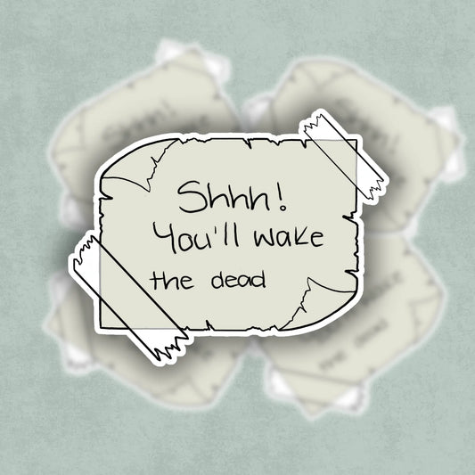 Illustrated text 'Shhh! You'll wake the dead" on a taped piece of curled and worn paper